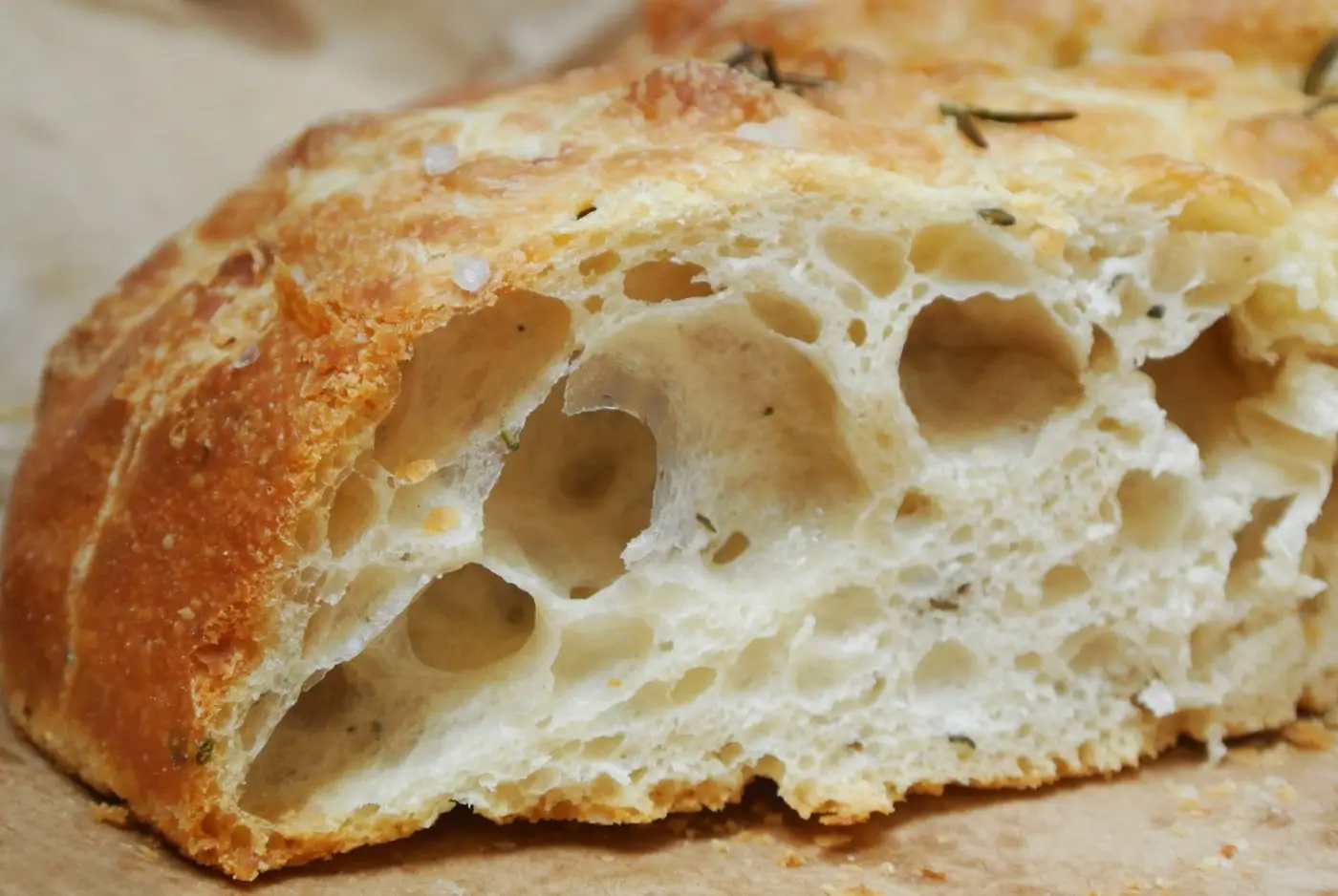 A cut piece of focaccia showing an airy crumb